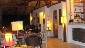 A cozy interior with a dining area, a bar, and a seating space. - Lodge Margouillat (Paquera)