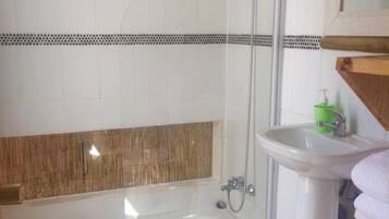 Un baño con bañera, ducha, lavabo e inodoro.
