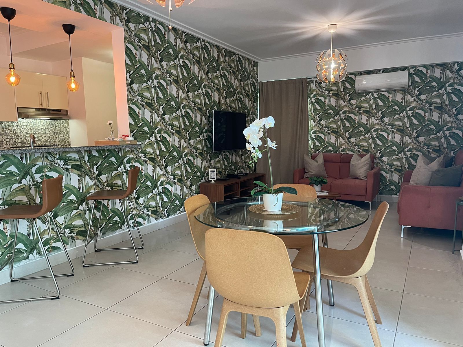 A modern living space with a dining area, kitchen, and seating area.