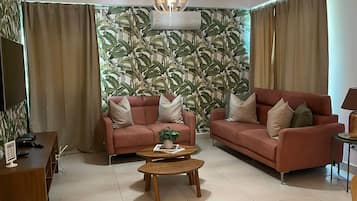Ein Wohnzimmer mit zwei Sofas, einem Couchtisch und einem Fernseher.