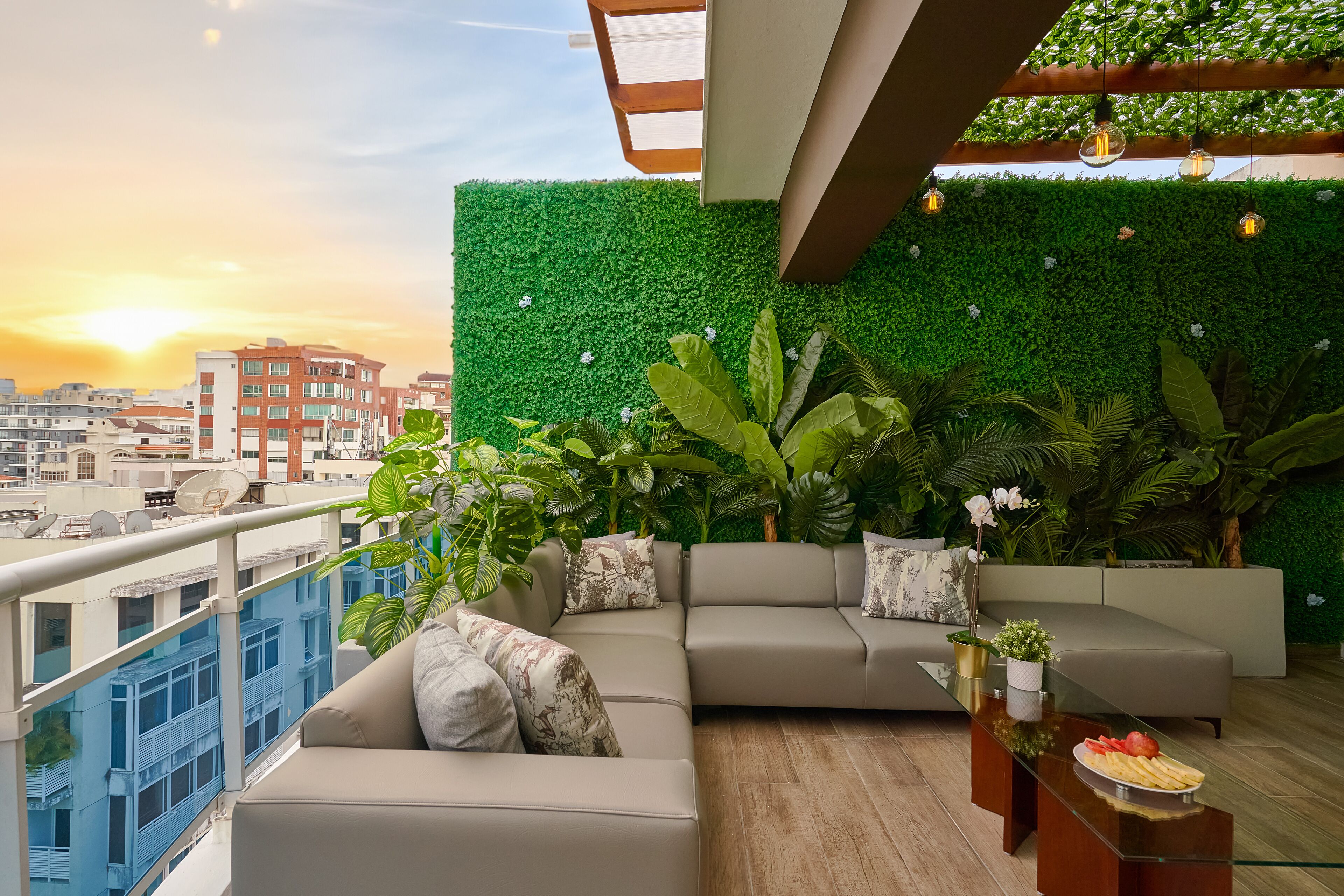 A modern living room with a green wall, a sectional sofa, and a glass coffee table.