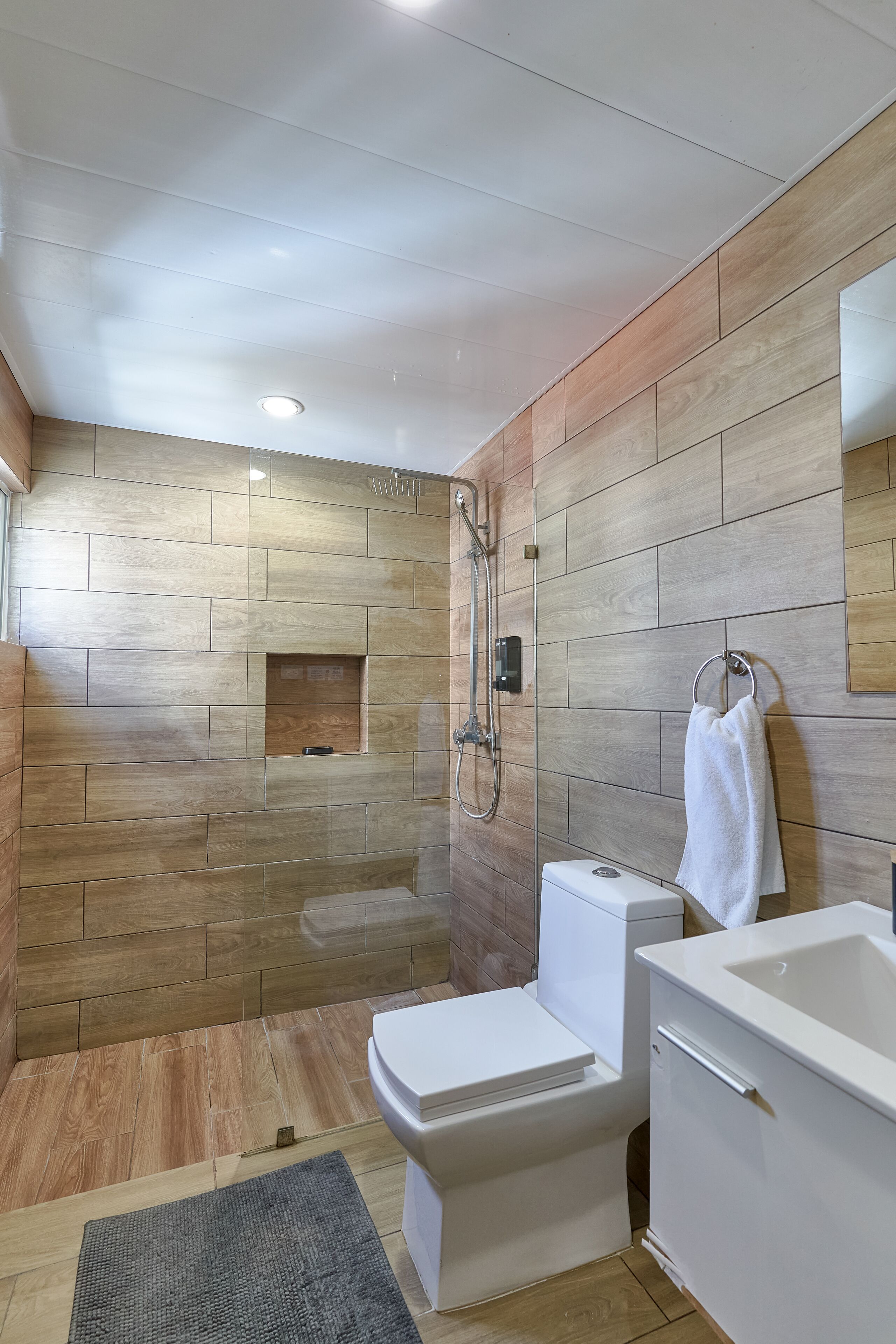 A modern bathroom with a shower, toilet, and sink.