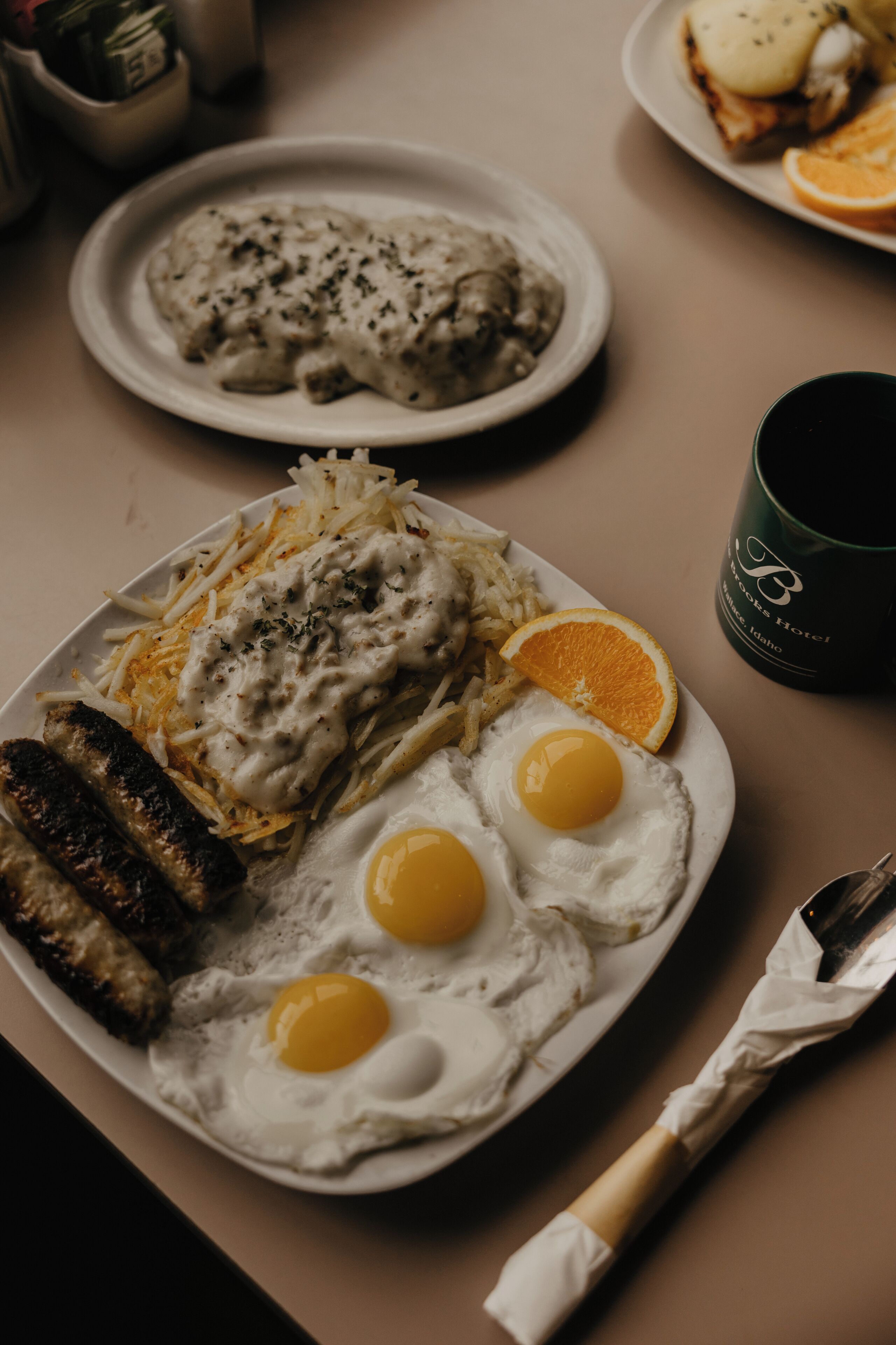 A breakfast plate with eggs, sausages, and hash browns.