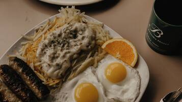 A breakfast plate with eggs, sausages, and hash browns.
