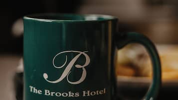 A green mug with a logo and text indicating it is from The Brooks Hotel in Wallace, Idaho.