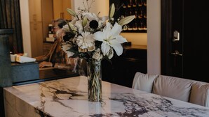 A reception desk with a marble top, a vase of white flowers, and a sign reading "Brooks Hotel". - The Brooks Hotel (Wallace)