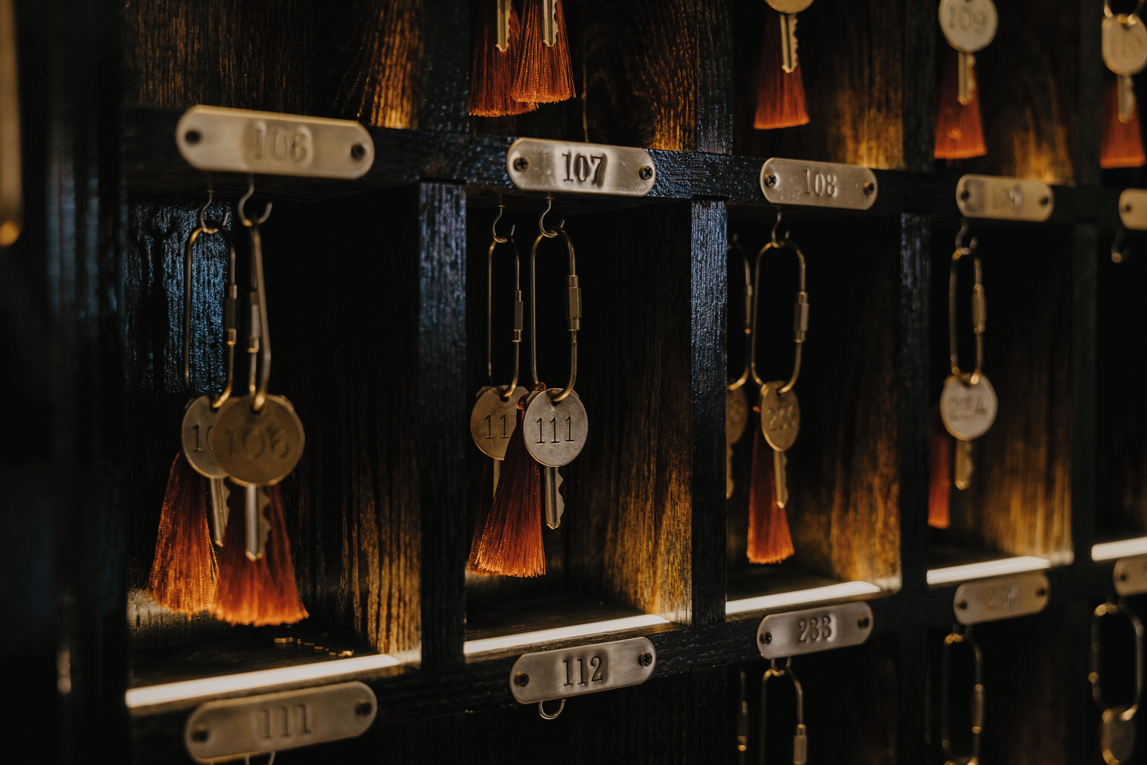 A close-up of a key rack with numbered keys and tags, indicating a secure storage system for guests' keys.