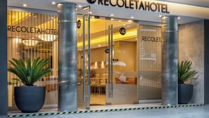 Das Hotel RECOLETAHOTEL mit Glastür, Pflanzen in Töpfen und modernem Design.