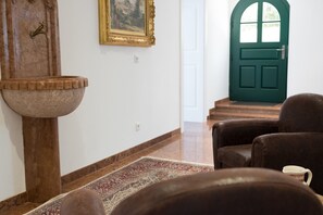 Una habitación con un lavamanos de piedra grande, una puerta verde y un sillón de cuero marrón.