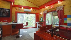 A cozy cabin interior with a kitchen, dining area, and bar. - Castle of Magic Pension (Hoengseong)