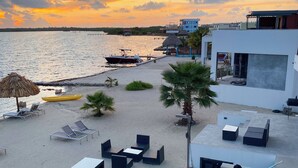 A beachside resort with a pool, lounge chairs, and a sunset view. - Playa De Sala (San Pedro)