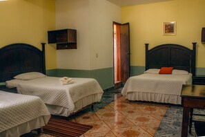 A hotel room with two beds, a wooden headboard, a small wooden cabinet, and a tiled floor. - Hotel Santa Maria (Panajachel)
