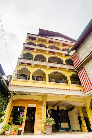 A multi-story building with a reception area, balconies with railings, and potted plants. - Hotel Santa Maria (Panajachel)