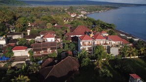 Un pueblo costero con casas, una playa y una montaña al fondo.