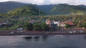Un pueblo costero con casas, una playa y montañas al fondo.
