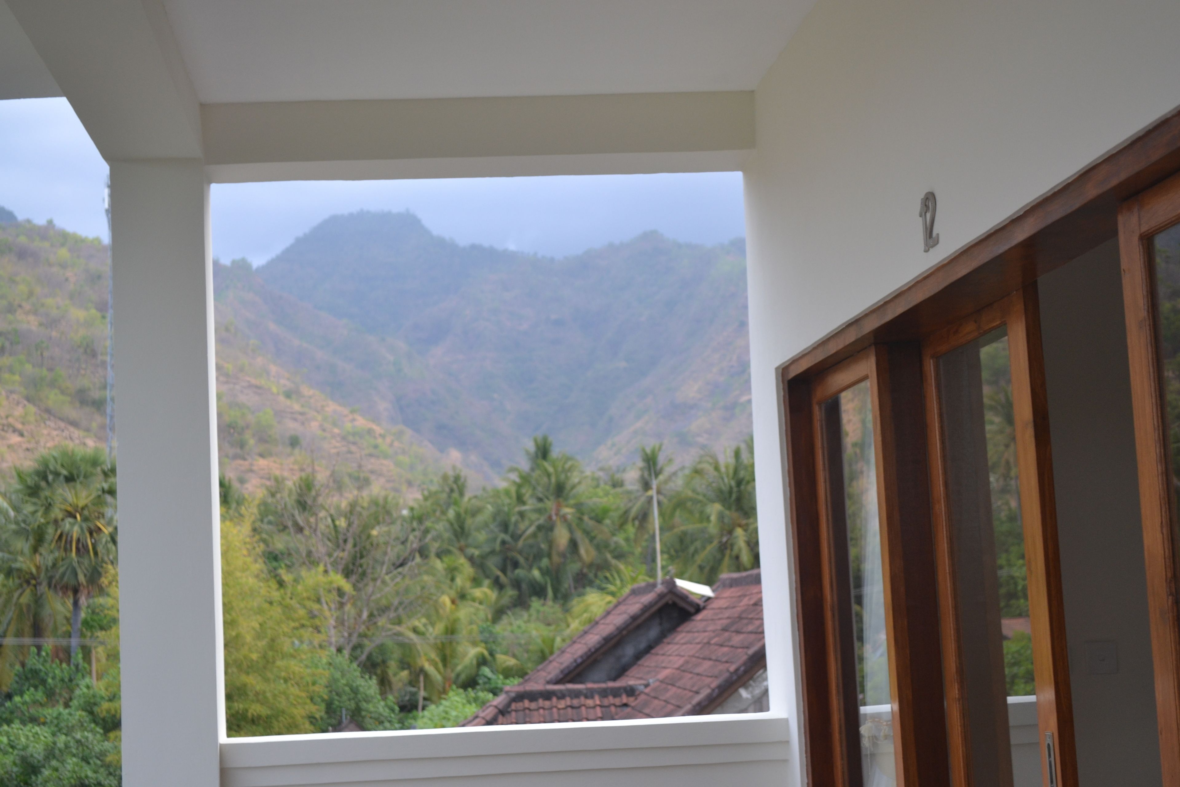 A room with a view of a mountainous landscape through a window.