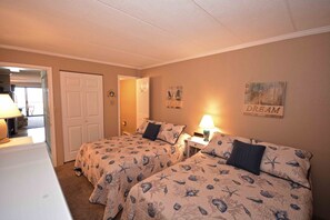 A bedroom with two beds, each with a starfish and shell pattern bedspread, a white door, and a wall with a 'RELAX' sign. - Stylish, eclectic 1 bedroom oceanfront condo with free WiFi, flat screen televisions, and a spectacular view of the ocean located in quiet midtown and only steps from the beach! (Ocean City)