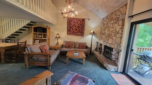 Ein gemütliches Wohnzimmer mit Kamin, Treppe und Essbereich.