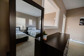 A bedroom with a bed, bedside table, lamp, and a potted plant. - Comfort and Convenience in Downtown Sitka - Suite A (Sitka)
