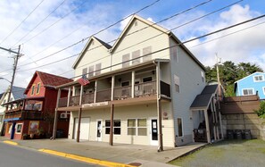A two-story building with a balcony on the second floor, a visible entrance, and a sign indicating 'Pull Tabs'. - Comfort and Convenience in Downtown Sitka - Suite A (Sitka)