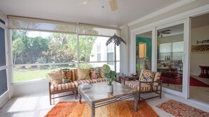 A spacious living room with a large window, a ceiling fan, and a view of the outdoors.