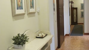 A hallway with a white console table, a potted plant, and two framed artworks on the wall. - Ideal starting point for visiting Portofino, Riviera, Genoa, Cinque Terre (Rapallo)