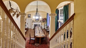 A grand staircase leading to a dining area with a chandelier, arched ceilings, and a red carpet. - Classically beautiful large family friendly retreat, situated on the Moray Firth (Moray)