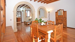 Un comedor con mobiliario de madera, un arco de piedra y un espejo en la pared.