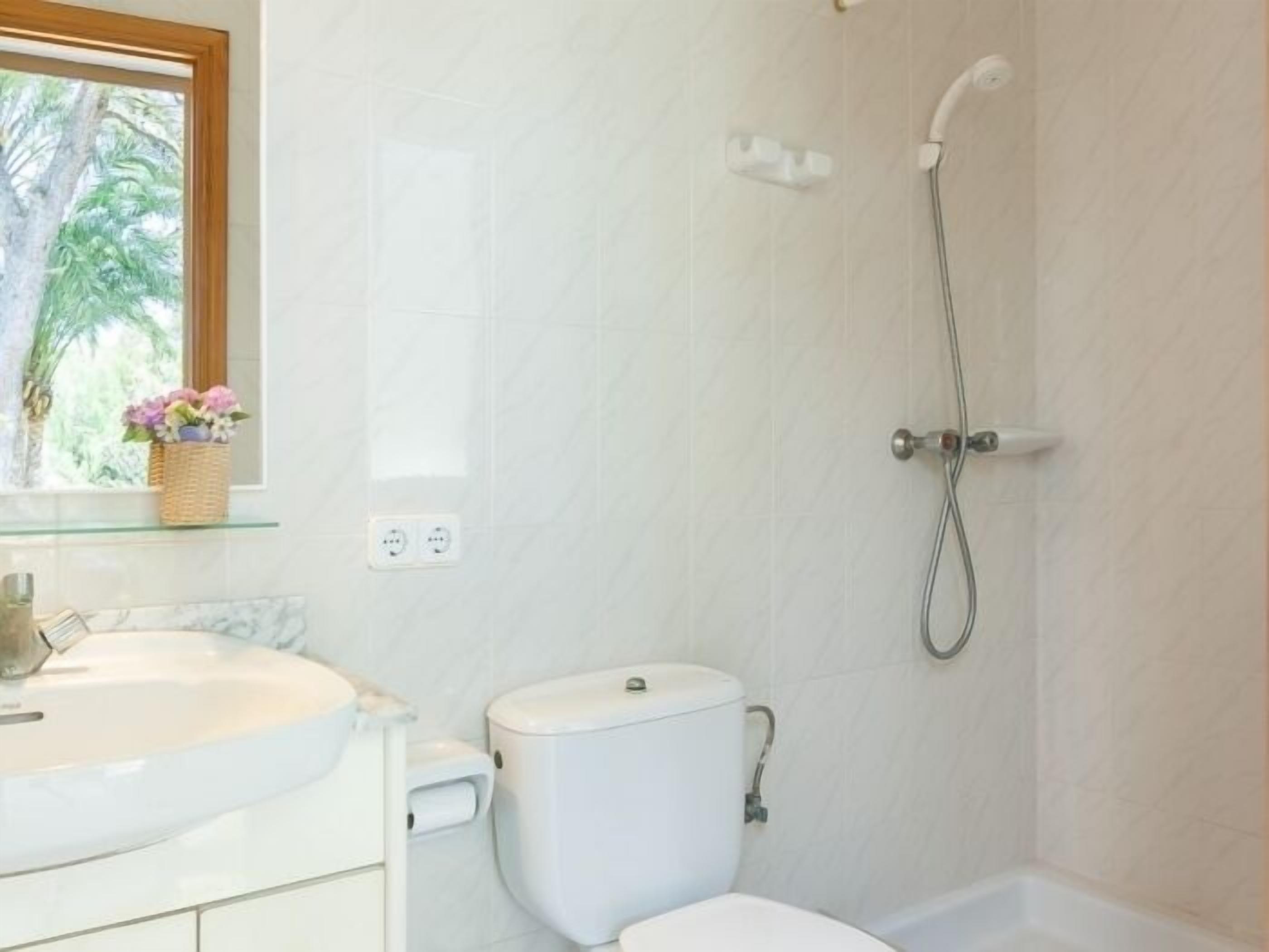 Un baño con inodoro, lavamanos y ducha.