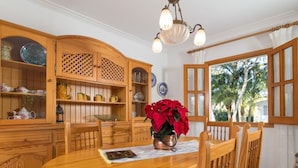 A wooden dining area with a round table, chairs, and a chandelier. - Marblava - Cosy villa with swimming pool 100 m from the beach (Muro (Platja de Muro))
