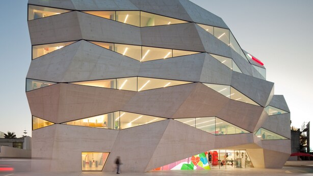 A modern building with a geometric facade and large glass windows.