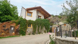 A two-story house with a stone facade and a wooden roof. - Romantic Escape with Terrace (La Omañuela, León)