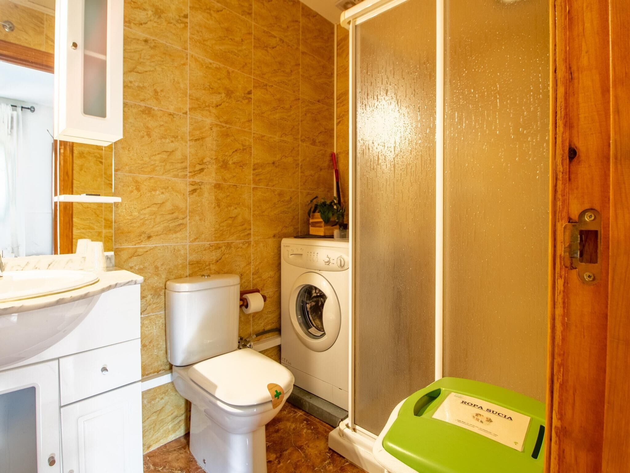 Une salle de bain équipée de toilettes, d’un lave-linge et d’un marchepied vert pour faire de l’exercice.