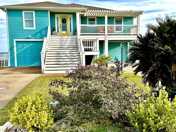 A two-story house with a front porch, a garage, and a balcony.