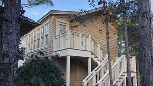 A two-story house with a balcony and a staircase leading to the upper floor. - Steps away from Camp Watercolor Amenities  (Santa Rosa Beach)