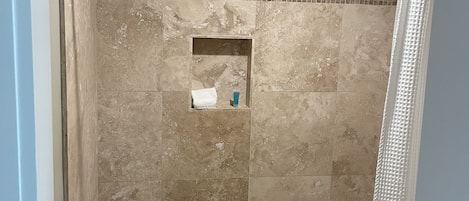 A bathroom with a bathtub, shower curtain, and tiled walls.