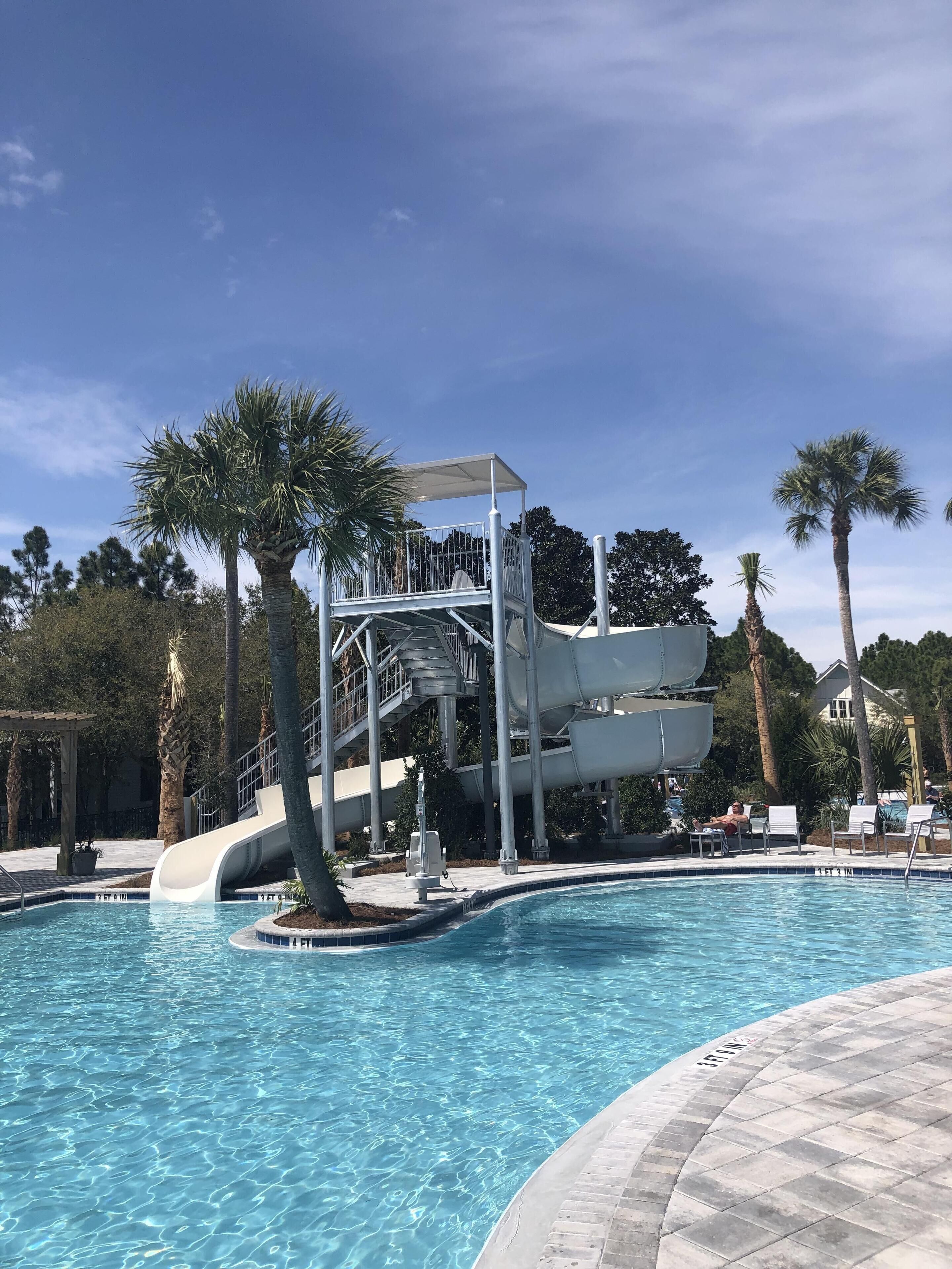 A swimming pool with a water slide and a covered area.