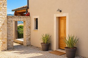 Un bâtiment en pierre avec une porte en bois et des plantes en pot.