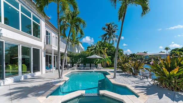 A swimming pool with a hot tub, surrounded by palm trees and lounge chairs. - Waterfront Estate Exclusive-Paradise Lighthouse Point Florida Private Pool/Spa (Lighthouse Point)