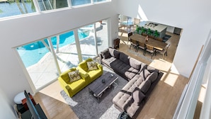 A modern living room with a pool, a dining area, and a view of the water. - Waterfront Estate Exclusive-Paradise Lighthouse Point Florida Private Pool/Spa (Lighthouse Point)