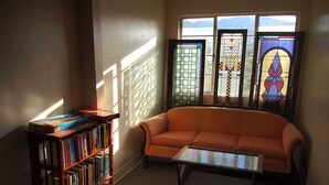 A cozy living room with a leather sofa, a coffee table, and a bookshelf filled with books.