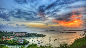 A coastal town with boats, buildings, and a sunset.