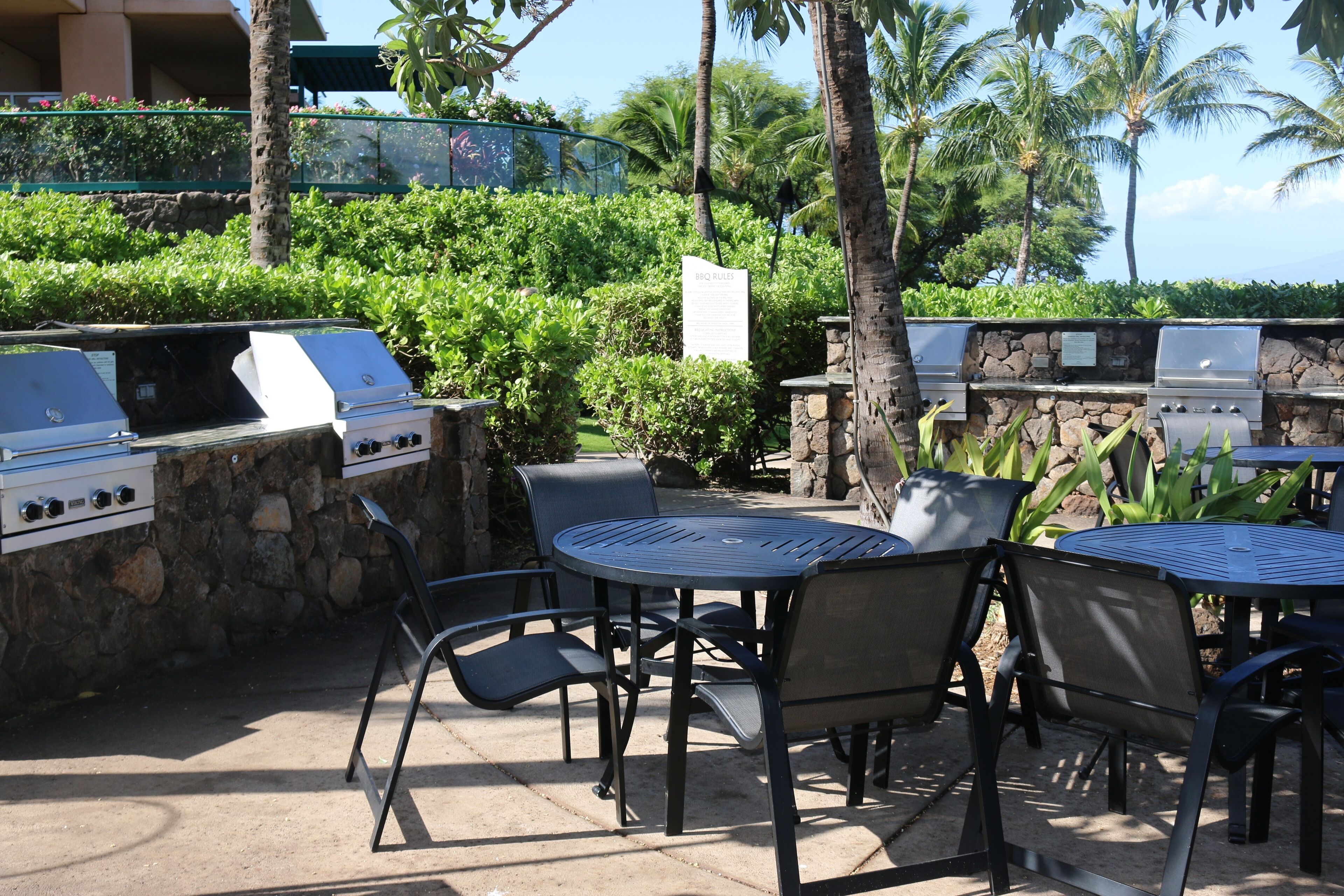Eine Terrasse im Freien mit Grill, Stühlen und Tisch.