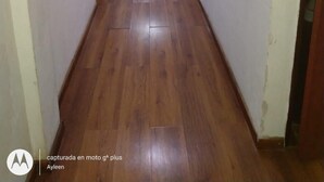 A long, narrow hallway with wooden flooring and white walls. There are ceiling lights and fire extinguishers visible. - Residencial Ski (Esquel)