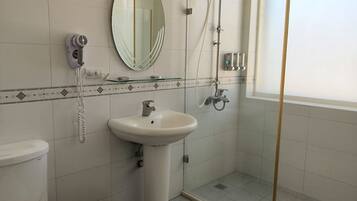 Une salle de bain équipée de toilettes, d’un lavabo et d’une douche.