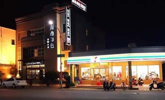 Un edificio con un letrero que dice "Coffee Shop" y otro letrero con caracteres chinos. Hay scooters estacionados y un coche blanco frente al edificio.