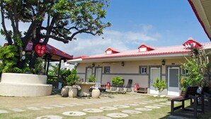A traditional Japanese-style building with a red tiled roof, stone lanterns, and a stone pathway leading to the entrance. - Landscape Rural B&B (Checheng)