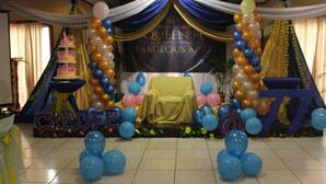 A decorated stage with a banner reading "Queen F Fabulous at 77", balloons, and a cake. - Benguet Prime Hotel (Baguio)