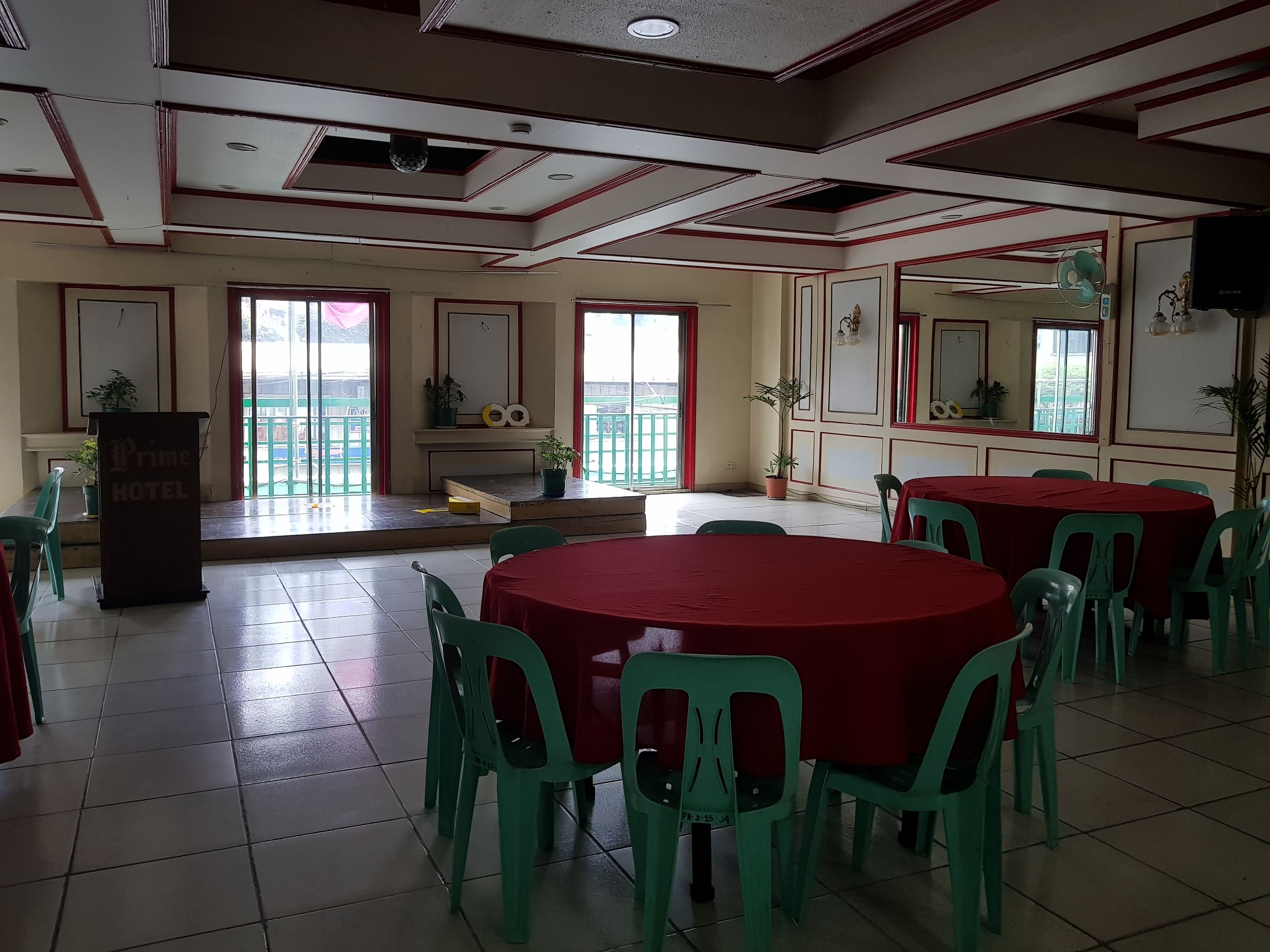 A hotel room with a balcony, a podium, and a table with chairs.