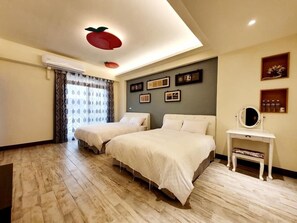 Une chambre d’hôtel avec deux lits, une coiffeuse avec un miroir et un plafond orné d’un luminaire en forme de fruit.